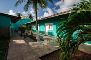 a patio with chairs and a blue house at Pousada da Villa in Fernando de Noronha