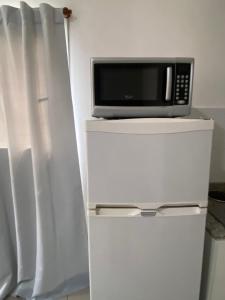 a microwave sitting on top of a refrigerator at La Esquina AT in San Pedro +33 photos