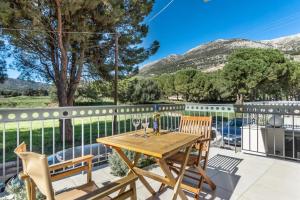 a wooden table and chairs on a patio with a fence at G.Living 365 in Agia Effimia