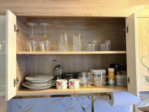a cupboard filled with glasses and plates and dishes at Ivory & Rose Studio in Tartu +5 photos