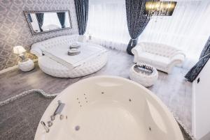 une grande salle de bains avec baignoire et un salon dans l'établissement Jacuzzi Romantic Apartment, à Klaipėda