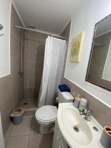 a white bathroom with a toilet and a sink at La Esquina AT in San Pedro