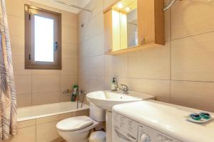 a white bathroom with a sink and a toilet at G.Living 365 in Agia Effimia +29 photos