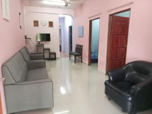 a living room with two couches and a television at Hanny Cozy Homestay in Kuala Lipis