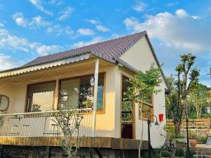 a small yellow house with a roof at Nhà Bên Hồ in Bảo Lộc