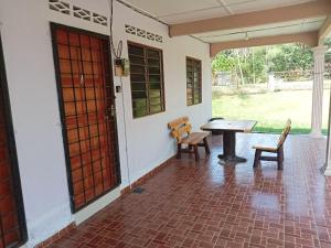a patio with a table and chairs in a house at Hanny Cozy Homestay in Kuala Lipis