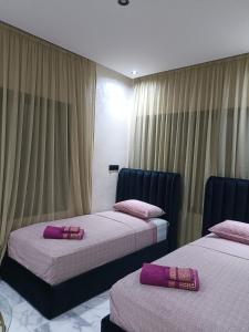 two beds in a hotel room with purple pillows on them at Résidence Escalade 1 in El Jadida