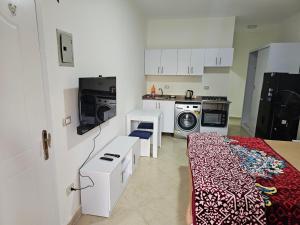a kitchen with a bed and a washing machine at Ground floor Garden & Pool & Beach Studio in Sharm El Sheikh