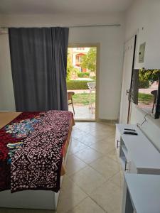 a bedroom with a bed and a door to a patio at Ground floor Garden & Pool & Beach Studio in Sharm El Sheikh