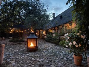 a lantern sitting in the middle of a stone courtyard at Rubensholm Bed & Breakfast in Brösarp