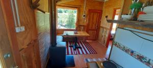 an inside view of a wooden train room with a table at Cabañas Entre Mañios y Coigües in Villa Santa Lucía