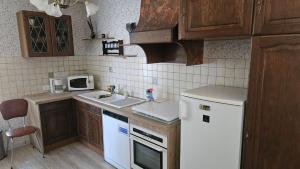 a kitchen with a white refrigerator and a sink at le logis des Chabannes in Saint-Angel +2 photos