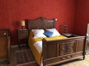 a bedroom with a large bed and a red wall at le logis des Chabannes in Saint-Angel