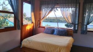 a bedroom with a bed with a view of the water at Nhà Bên Hồ in Bảo Lộc