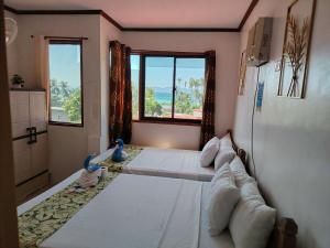 a bedroom with a large bed with two babies in it at Brenmariel Tourist Inn in El Nido