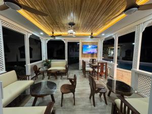 a living room with chairs and tables and windows at Villas Carela, Villas Privadas con Piscina y Jacuzzi a 2 Minutos de la Playa de Cabarete in Cabarete