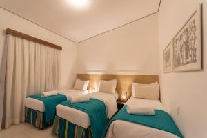 a room with three beds with green and white at Pousada da Villa in Fernando de Noronha
