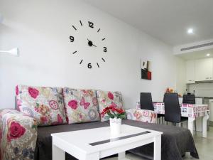 a living room with a couch and a clock on the wall at Vista Bella in Torrevieja