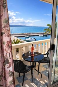 a table on a balcony with a view of the ocean at Apartmány Júlia in Živogošće