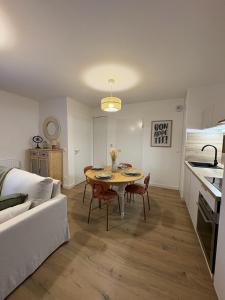 a kitchen and living room with a table and a couch at Ecrin de nacre Appartement de Standing in Courseulles-sur-Mer