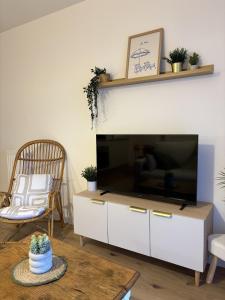 a living room with a large flat screen tv at Ecrin de nacre Appartement de Standing in Courseulles-sur-Mer