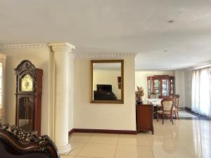 a living room with a clock and a mirror at Homely Palace in Midrand