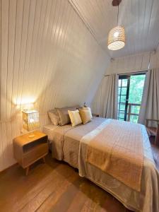 a bedroom with a bed and a table with a lamp at Cabana Eucalipto in Itatiaia