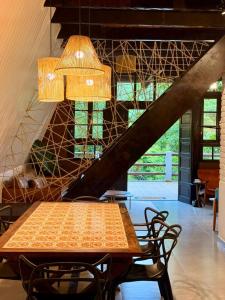 a table and chairs in a room with a staircase at Cabana Eucalipto in Itatiaia