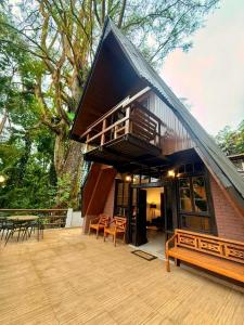 a house with a roof with a deck and chairs at Cabana Eucalipto in Itatiaia