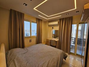 a bedroom with a bed in a room with windows at Salalah Apartment in Cairo