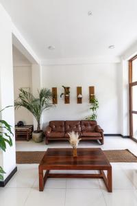 a living room with a brown couch and a coffee table at Sea Cloud Dalawalle in Unawatuna