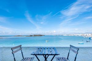 two chairs and a picnic table in the water at Hotel Lo Scoglio in Porto Cesareo