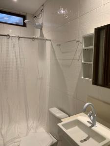 a bathroom with a shower and a toilet and a sink at A passos do paraíso!! in Lauro de Freitas