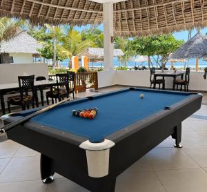 a pool table in a room with a pool at Amani Palms by Manolo Beach Resort in Uroa