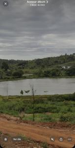 a river in the middle of a field next to a road at Temporada Monte gordo in Camacari