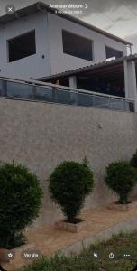 a building with two trees in front of it at Temporada Monte gordo in Camacari