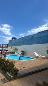 a swimming pool on the side of a building at Temporada Monte gordo in Camacari