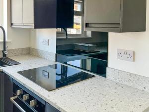 a kitchen with black and white counters and cabinets at Thirslet in Maldon