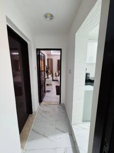a hallway with white walls and a black door at Velmora Cozy 2BR Apartment 20 in Abu Dhabi