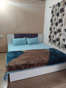 a bed with blue pillows and a blanket on it at Fortune Heritage Resort in Baori Thikria