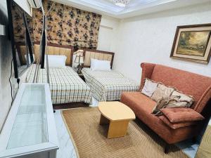 a living room with two beds and a couch at Velmora Cozy 2BR Apartment 20 in Abu Dhabi