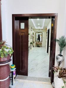 an open door to a hallway with potted plants at Velmora Cozy 2BR Apartment 20 in Abu Dhabi
