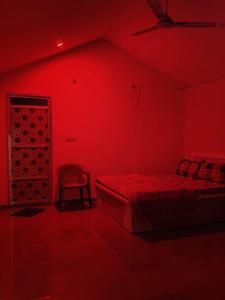a red room with a bed and a chair at Fortune Heritage Resort in Baori Thikria