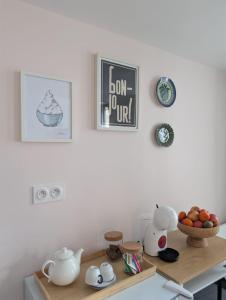 a kitchen counter with a table with a bowl of fruit at La loge Diane, à deux pas du château et son jardin à la française in Chantilly