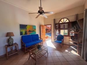 a living room with a blue couch and chairs at Bel Air/Sutton in San Juan del Sur