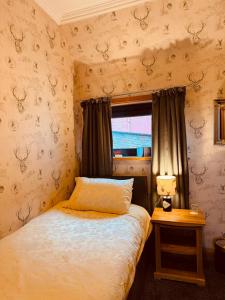 a small bedroom with a bed and a window at Lakeview Guest House in Stranraer
