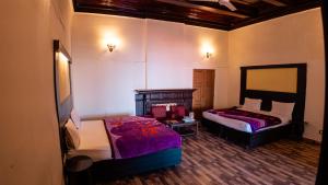 a bedroom with two beds and a table in it at Hotel Dalziel in Shimla