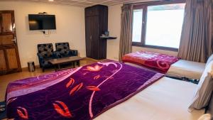 a room with two beds and a window and a chair at Hotel Dalziel in Shimla