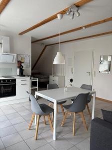 a kitchen and dining room with a white table and chairs at FEWO Eggenstein beim KIT in Eggenstein-Leopoldshafen
