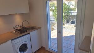 a kitchen with a washing machine and a sink at Gite d'Ossau in Lescar